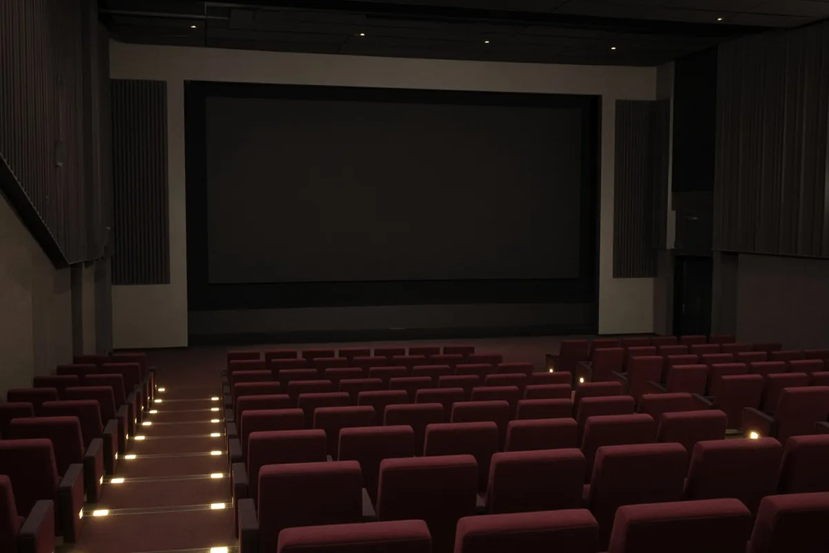 Empty commercial cinema with burgundy seats and a blank dark screen